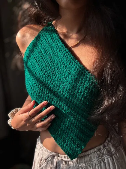 A close-up of my dark green asymmetrical top. The dense stitch work makes it feel really high-quality and structured.