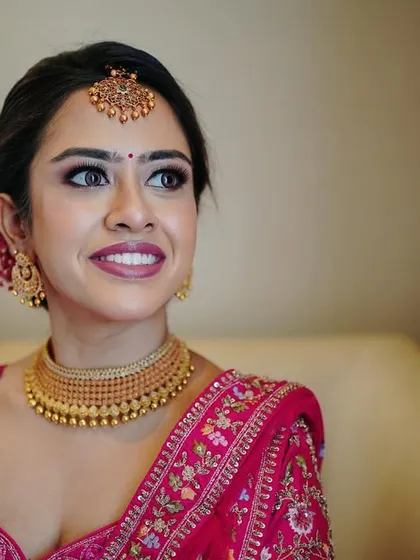 A close-up portrait capturing the bride's happy and hopeful expression. Her flawless makeup and stunning jewelry are highlighted in this beautiful shot.