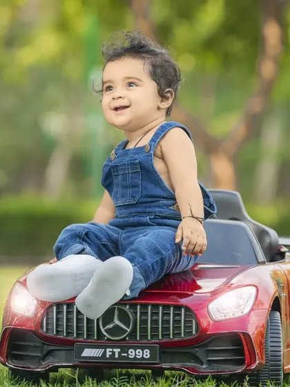 Taking the fun outdoors! This little dude felt like the king of the road in his shiny red toy car. Outdoor baby photoshoots are perfect for capturing your child's adventurous spirit in natural light.
