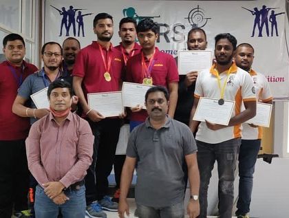 A group of our adult male shooters after a successful competition, proudly holding their certificates and medals.