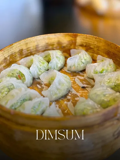 Another variety of my steamed dim sum, with a greenish dough indicating a vegetable filling. The translucent skin and beautiful shape are a testament to the skill of my chefs.