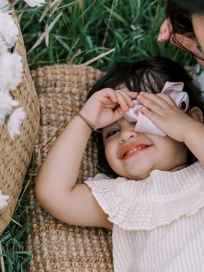 A playful moment of peek-a-boo during a family picnic. These are the fun, candid shots that families will look back on and smile.