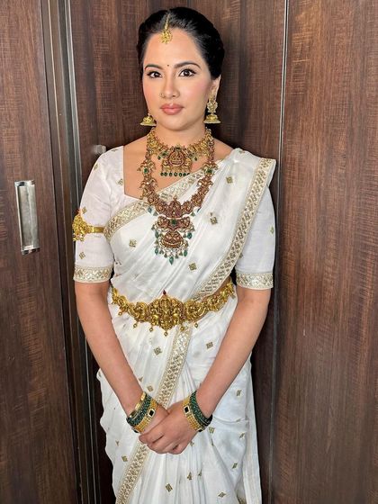 The full view of this serene and beautiful look. The white saree provides a perfect canvas for the radiant makeup and statement jewelry.