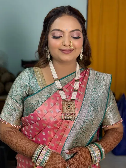 A soft and elegant look for a pre-wedding ceremony, featuring a pink and silver saree with minimal, glowing makeup.