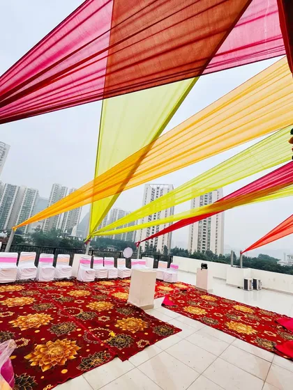 Another angle of the rooftop decoration, showing how the drapes create a colorful canopy over the seating area, with the city skyline in the background.