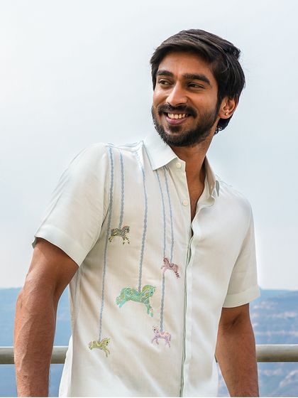 Introducing our 'Prancing Ponies' shirt, crafted from eco-friendly bamboo fabric. Adorned with intricately embroidered carousel horses, this shirt embodies childhood nostalgia and carefree elegance.