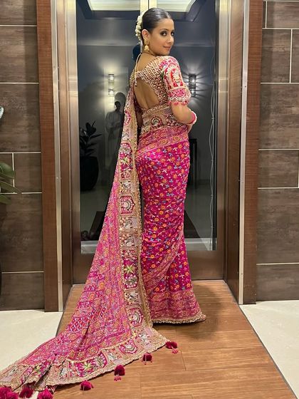 A dramatic and glamorous look for actress Isha Malviya. The traditional pink saree is paired with a smokey eye and a sleek bun for a powerful style statement.