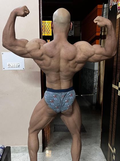 The other side of the coin. A back double biceps pose showing the result of countless hours of work.