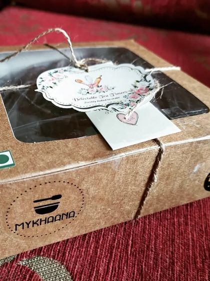 Our treats are packed with a personal touch. This rustic cardboard box, tied with twine and a custom tag, holds our delicious home-baked biscotti, ensuring they arrive fresh and full of love.