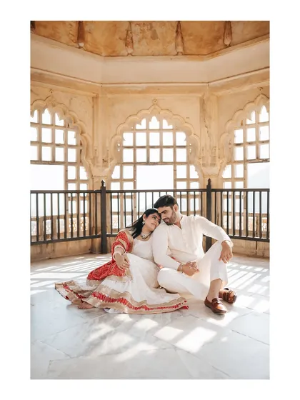 A peaceful moment shared by the couple inside a sunlit pavilion at Amer Fort, showcasing the beautiful play of light and shadow.