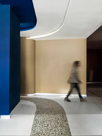 A curved corridor at the MARC Auditorium, where a path of terrazzo flooring guides movement. The interplay of color, material, and form creates a series of distinct yet connected spatial experiences.