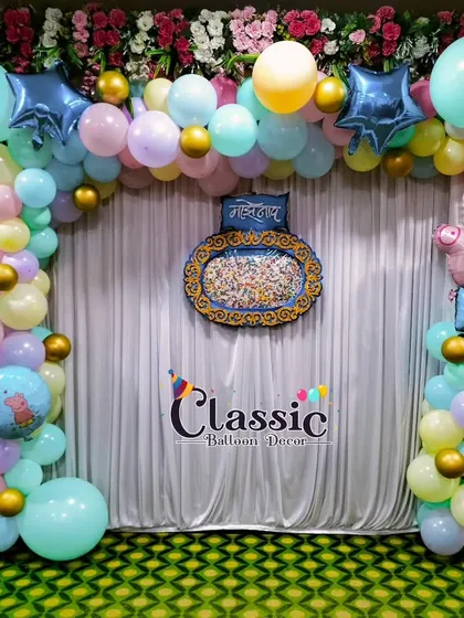 A fun Peppa Pig theme for a naming ceremony. The pastel balloon arch is decorated with a Peppa Pig foil balloon and other themed elements.