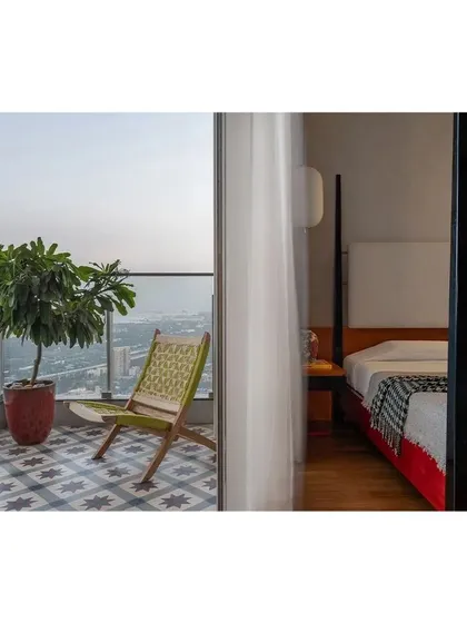 For this bedroom, we designed a four-poster bed in lacquered wood, inspired by Channapatna toys, connecting the modern apartment to the client's Bangalore roots.