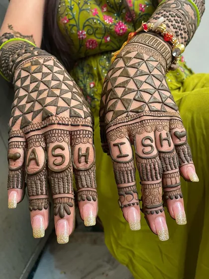 A creative way to spell out your love. The groom's name, 'ASHISH', is incorporated into the design, with each letter getting its own space on the bride's fingers.