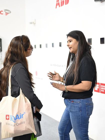 A member of our team in a detailed discussion with a visitor about our wellness solutions. You can see the IQAir tote bag, a brand synonymous with quality air, which reflects the shared interest in creating healthier indoor environments.