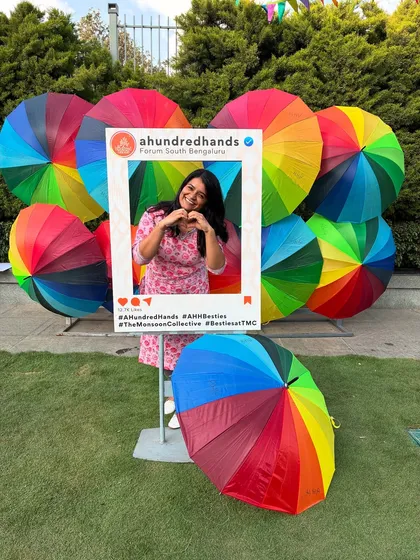 Spreading the love for handmade. A happy visitor shares a heart sign at our vibrant photo booth, a popular feature at our artisan markets.
