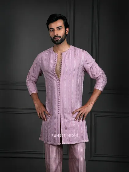 Inspired by heritage, designed for today. This dusty salmon kurta set features subtle sheen, loop buttons, and woven geometry that embody timeless sophistication.