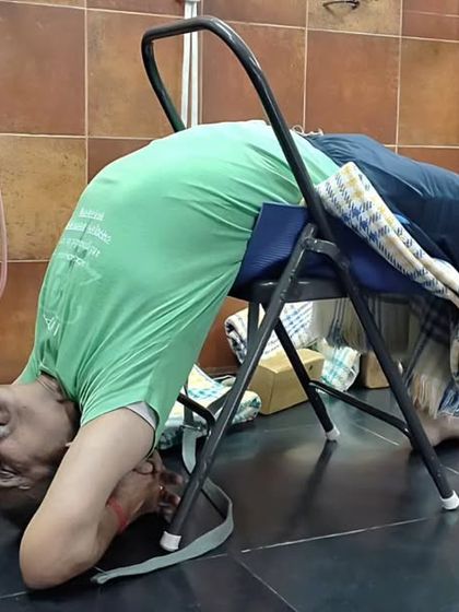 A supported backbend over a chair, a preparation for Urdhva Dhanurasana (Wheel Pose). The chair supports the thoracic spine, helping to open the chest and shoulders safely.