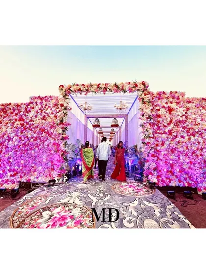 A beautiful floral entrance tunnel designed to wow guests as they arrive. The walls are covered in thousands of pink and white flowers, creating an immersive and luxurious welcome experience.