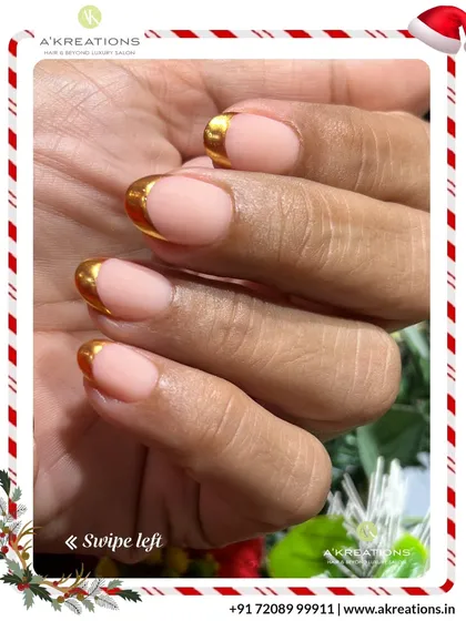 A glamorous and modern chrome French manicure. This design features a natural nude base with bold, reflective gold tips for a striking holiday look.