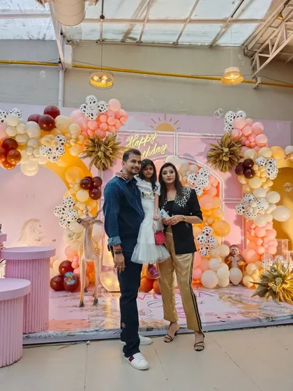 The birthday girl and her family pose in front of the beautiful pastel animal-themed backdrop, a perfect setting for creating lasting memories.