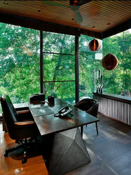 Another glimpse of the T House study, showing its relationship to the main house. The design uses a consistent material palette of wood, stone, and glass to create a cohesive architectural language throughout the project.