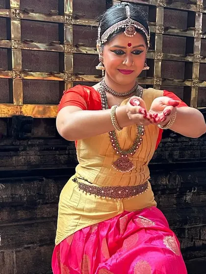 A close-up from our dance tour in Kerala, dressed in a vibrant pink and gold costume. Performing in different cities allows us to share our art with new audiences and experience the local culture.