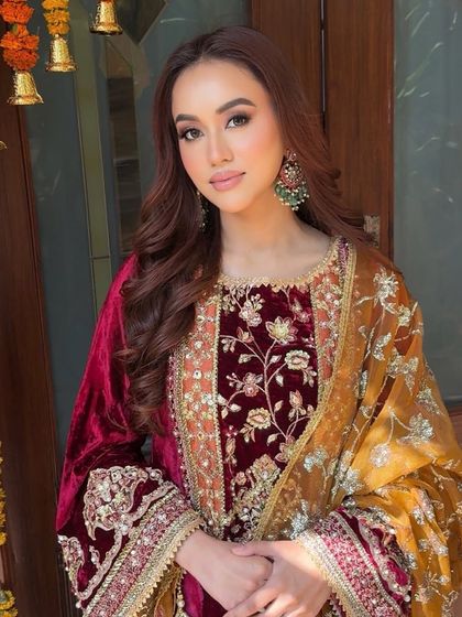 A beautiful portrait of the bride-to-be at her pre-wedding ceremony. Her makeup is soft and radiant, complementing the rich velvet of her Mohsin Naveed Ranjha outfit.