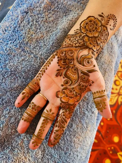 A beautiful floral design that flows from the wrist down the side of the hand, leaving the palm open. It's an elegant and modern choice.