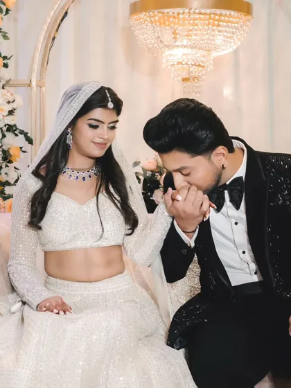 A chivalrous gesture as the groom kisses the bride's hand after the ring exchange. This romantic moment is captured beautifully against the elegant decor.