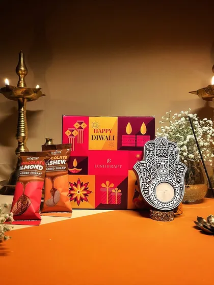 A vibrant Diwali hamper featuring a Hamsa hand candle holder and sugar-free chocolate bars. This is a great option for a stylish and health-conscious gift.