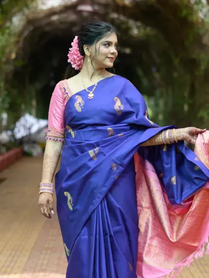 The royal blue Paithani saree with its pink border is the star here, complemented by a natural makeup look and a simple, elegant hairstyle.