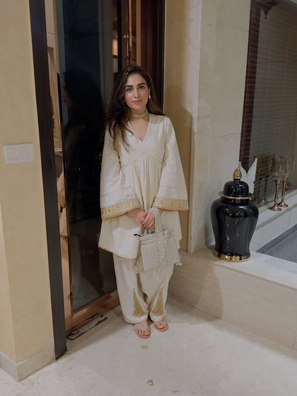 I designed this simple off-white suit with gold detailing on the sleeves and pants. It's a testament to how clean lines and subtle embellishments can create a very elegant look.