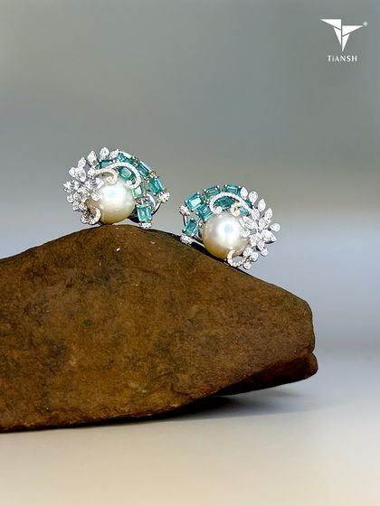 A matching pair of earrings to the pearl and emerald brooch, these studs are a beautiful story of nature's elements coming together in a harmonious design.