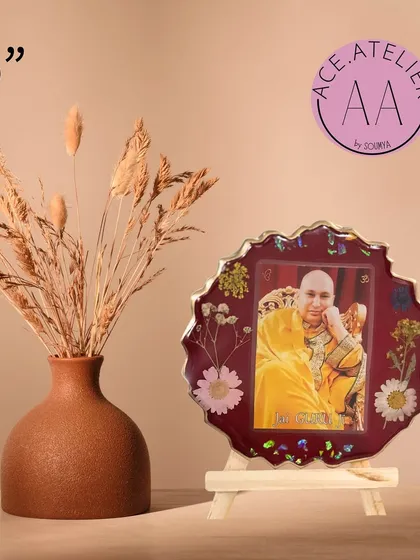 Another beautiful 6-inch Guruji photo frame, this one in a deep red resin with delicate floral accents.