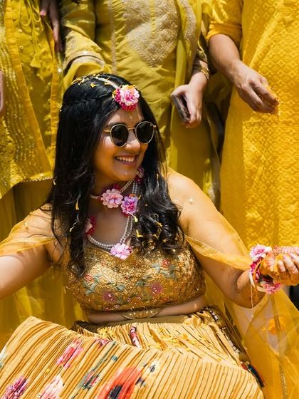 A happy bride during her outdoor Haldi ceremony, enjoying the celebration with her loved ones.