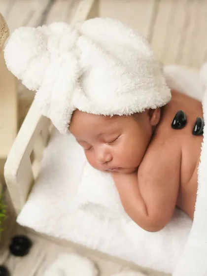 A close-up of the relaxed baby, sleeping through his spa treatment. It's a picture of pure peace and pampering.