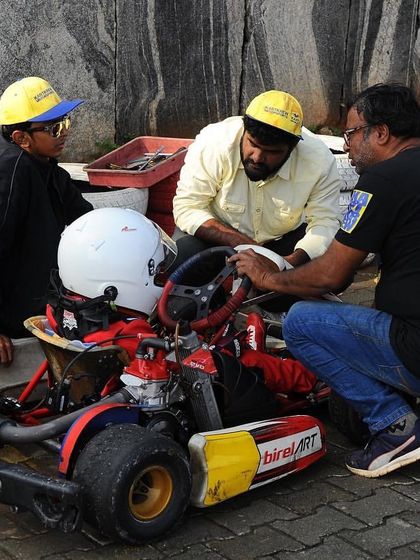 Our technical team and coaches working closely with a young driver, explaining the mechanics of the kart.