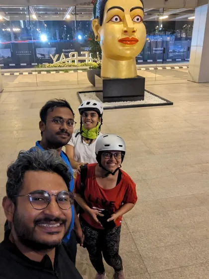 A fun group selfie in front of a sculpture at RMZ Ecoworld. A planned ride to Indiranagar turned into an unexpected adventure to Bellandur, filled with laughter and exploration.