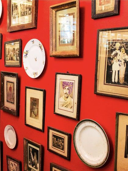 Our wall of portraits and plates tells a thousand tales. This collection of vintage photographs and heirlooms adds a personal and historical touch to our vibrant, red-walled interiors.