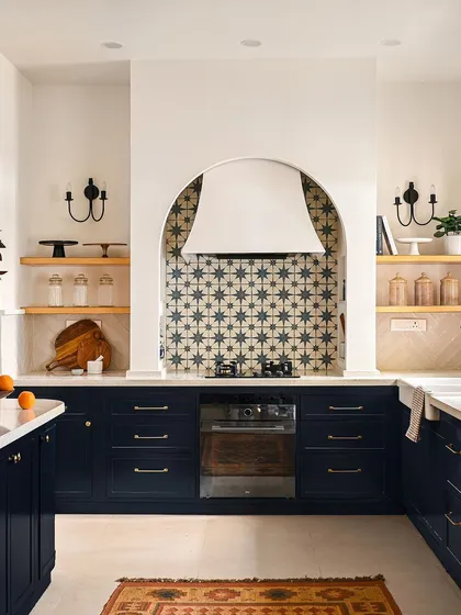 The kitchen is the heart of the home, and I designed this one to be a showstopper. The custom arched range hood, paired with a bold cement tile backsplash, creates a stunning focal point, while the deep blue custom cabinets provide ample, beautiful storage for a space that is as functional as it is breathtaking.