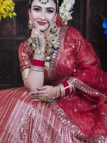 A smiling bride in a red gota patti lehenga, paired with a beautiful green and gold Kundan set. This shows how you can create a complete look at my studio.