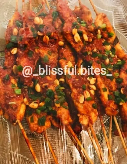 Here are the saucy and spicy Satay Chicken skewers after cooking, garnished with peanuts and spring onions. They are a flavourful and popular starter option.