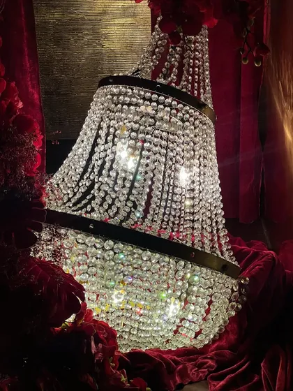 The decor featured opulent details like crystal chandeliers draped in red velvet, cascading floral arrangements, and candelabras that added to the romantic, high-end feel of the celebration.