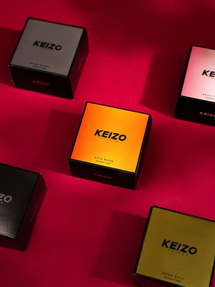 A flat-lay of the "Keizo" product line, showcasing the different packaging designs on a rich red background.