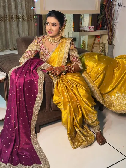 A full-length seated portrait, showcasing the beautiful drape of the yellow Nauvari saree.