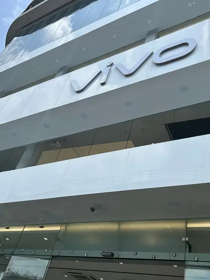 A close-up of the VIVO building's facade, showing the crisp white paneling and bold 3D lettering. The quality of exterior finishing is just as important as the interior.
