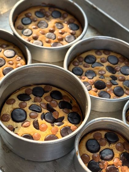 A fresh batch of our signature butter cakes, straight out of the oven. You can see the pools of melted Belgian chocolate in each one.