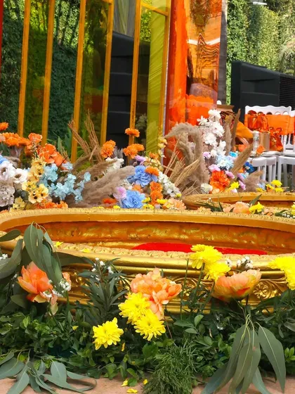 The 'Haldi kunds' ready for the ceremony, surrounded by a bed of colorful flowers.