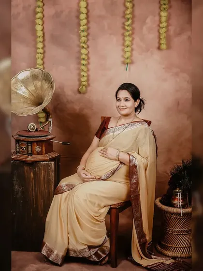 A serene portrait from one of our traditional maternity sessions. The combination of a beautiful cream saree, marigold flowers, and vintage props creates a truly timeless feel.